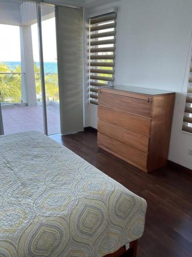 a bedroom with a dresser and a bed and a window at Sandy Shores in Trincomalee