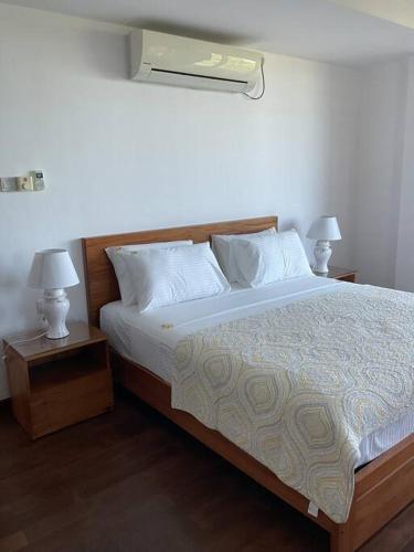 a bedroom with a large bed with two night stands at Sandy Shores in Trincomalee