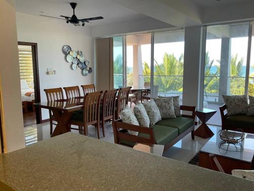sala de estar con sofá, mesa y sillas en Sandy Shores, en Trincomalee
