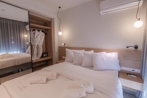 um quarto com uma grande cama branca com almofadas brancas em Aeson Premium Living em Volos