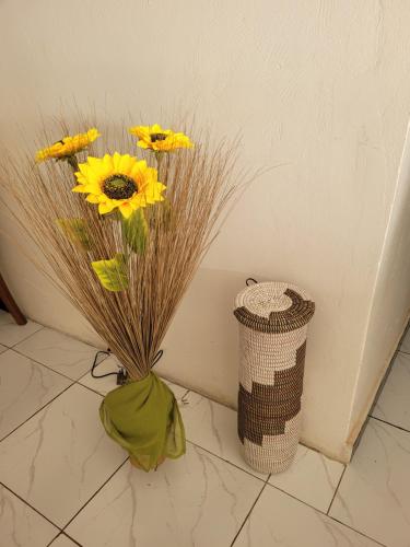a vase filled with yellow flowers sitting on a floor at Casa Djoko in Dakar