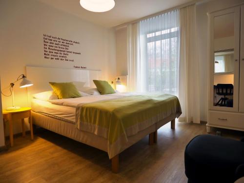 a bedroom with a bed and a large window at Hotel Villa Rückert in Graz