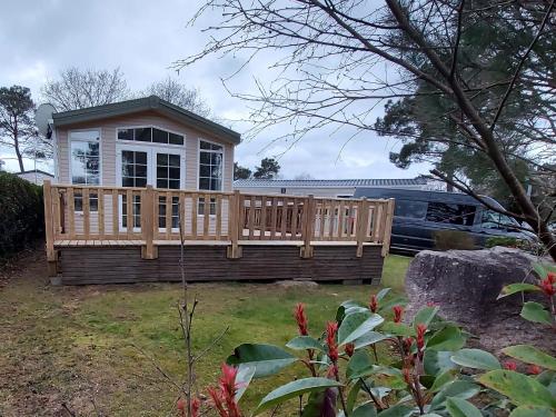 a house with a deck in the yard at Mobilhome - Kedidrouz du Léon - Kerlann - Pont Aven in Pont-Aven