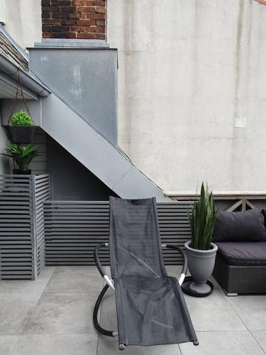 a chair sitting on a patio next to a stair case at Modern loftsleilighet in Fredrikstad