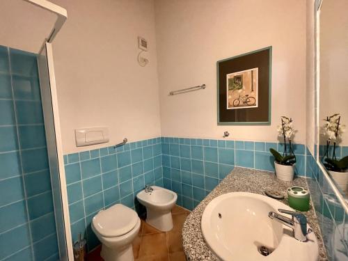 a bathroom with a white toilet and a sink at CAPO CODA CAVALLO VILLA SALINEDDA GIARDINO VISTA MARE in Capo Coda Cavallo