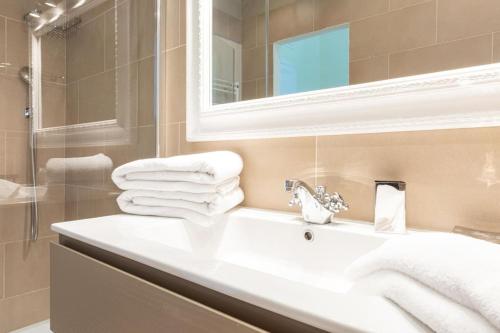 a bathroom with a sink and a mirror and towels at Spanish Steps Hills Apartment -TopCollection in Rome