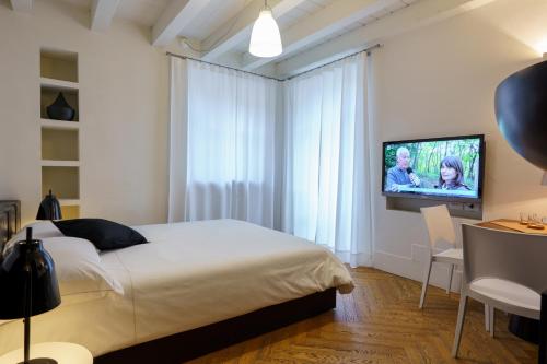 1 dormitorio con 1 cama y TV de pantalla plana en IL CANTUN, en Monforte dʼAlba