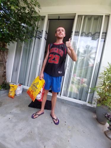 a man standing in front of a house holding a bag at CHEN VILLA - Near Airport in Negombo