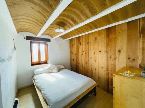 1 dormitorio con 1 cama con techo de madera en Cal Megui, 