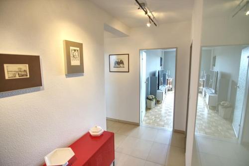 Habitación con mesa roja y baño. en Ferienwohnung mit herrlichem Ausblick meerwärts, en Wilhelmshaven