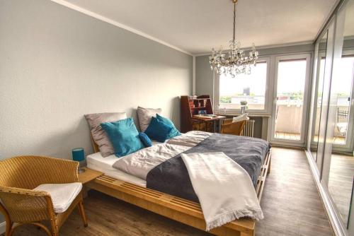 1 dormitorio con 1 cama grande con almohadas azules en Ferienwohnung mit herrlichem Ausblick meerwärts, en Wilhelmshaven