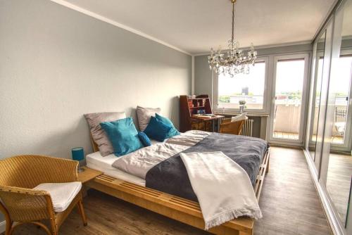 a bedroom with a large bed with blue pillows at Ferienwohnung mit herrlichem Ausblick meerwärts in Wilhelmshaven