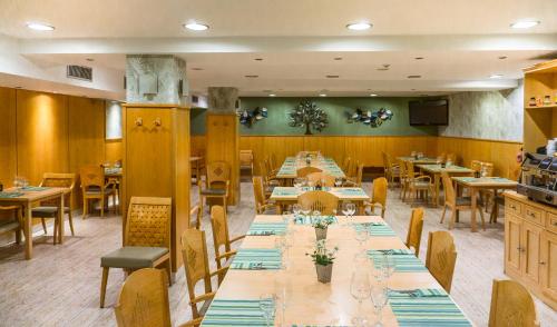 une salle à manger avec de longues tables et chaises dans l'établissement Hotel Jaqués, à Jaca