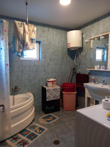 a bathroom with a tub and a toilet and a sink at Casa IOANA Corbu in Corbu