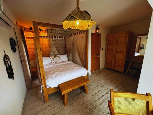 a bedroom with a canopy bed with a wooden floor at Fizzio Alaçatı Hotel in Alaçatı