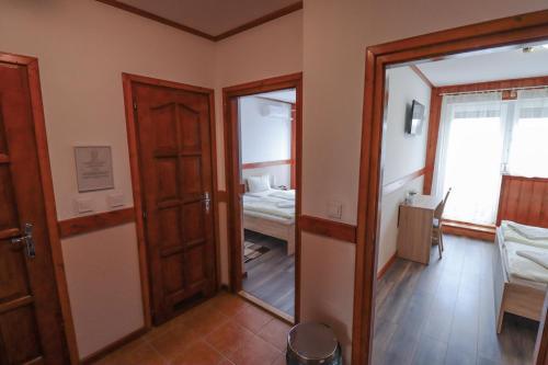 Habitación con puerta, espejo y dormitorio. en Vadkacsa Panzio, en Balatonkenese