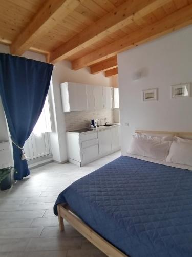 1 dormitorio con 1 cama azul y cocina en Domus plano de laczarulo Acciaroli, en Acciaroli