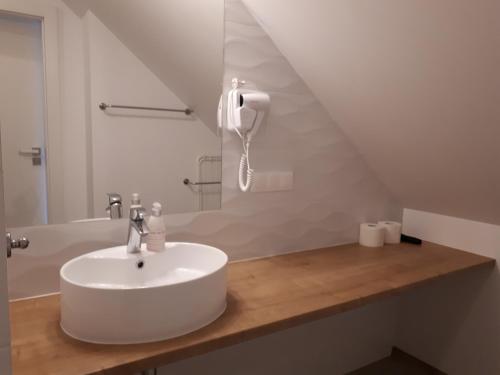a bathroom with a sink and a phone on a counter at Sosenka in Niechorze