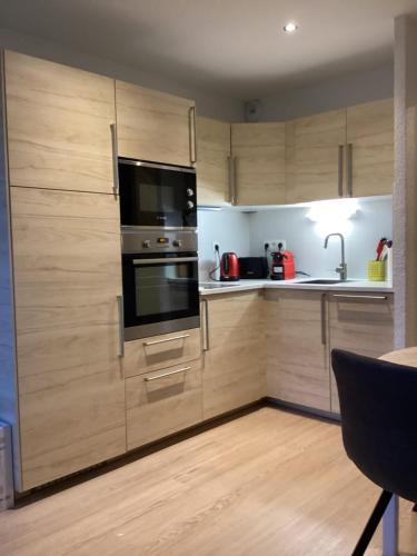 uma cozinha com armários de madeira e um forno preto em Duplex Aiguille du Midi furnished flat em Chamonix-Mont-Blanc