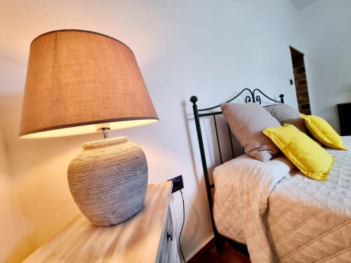 a lamp sitting on a table next to a bed at DA LAURA in Bottidda