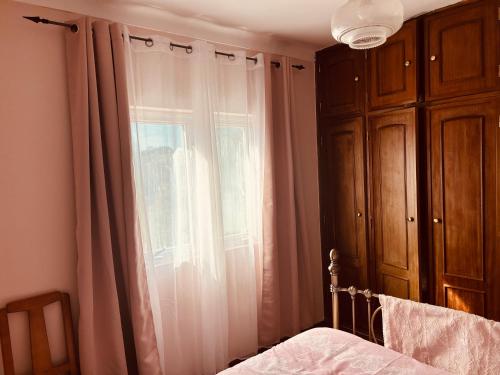a bedroom with a bed and a window with curtains at Mãe Home Story in Caldas da Rainha