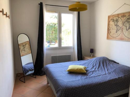 sypialnia z łóżkiem, lustrem i oknem w obiekcie Gîte « les rives de l’Ardèche » w mieście Ucel