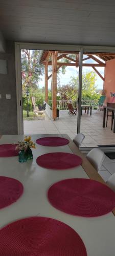 Cette chambre dispose d'une table avec des tapis rouges. dans l'établissement La Petite Maison, à Givry