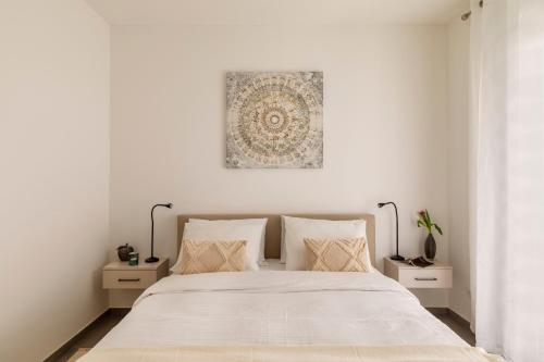 a white bedroom with a large bed with white sheets at Lugano Superior Suites - Free Parking in Lugano
