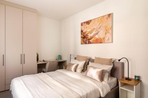 a bedroom with a bed and a painting on the wall at Lugano Superior Suites - Free Parking in Lugano