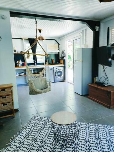 sala de estar con hamaca y cocina en L'Eucalyptus, en La Trinité