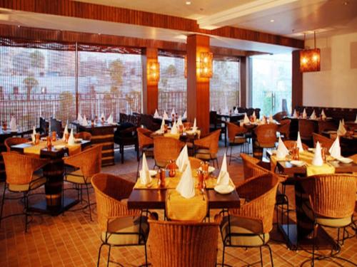 a restaurant with tables and chairs in a room at Hotel Palace Heights in New Delhi