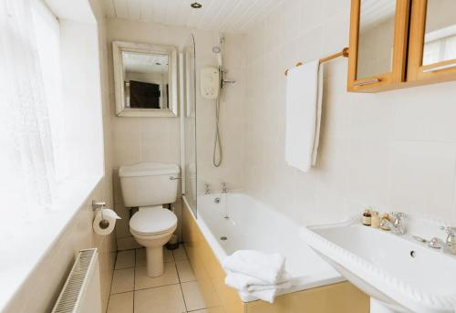 a bathroom with a toilet and a tub and a sink at CLIFFE COTTAGE - Countryside Cottage in Castleton, Peak District National Park in Castleton