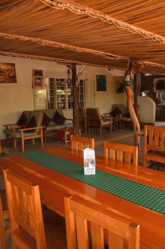 a wooden table in a room with tables and chairs at Kara-Tunga Safari Camp in Moroto