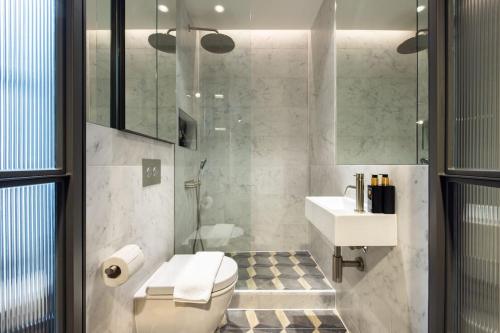 een badkamer met een toilet, een wastafel en een douche bij The Soho STAR in Londen