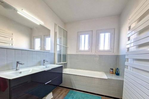 a white bathroom with a tub and a sink and a bath tub at Villa Familiale en Provence avec Piscine in Le Castellet