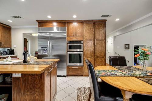 a kitchen with a wooden table and a kitchen with stainless steel appliances at Woodlands Vacation Home in Little Elm/ Frisco TX in Little Elm