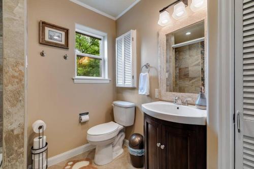 a bathroom with a toilet and a sink and a window at Woodlands Vacation Home in Little Elm/ Frisco TX in Little Elm