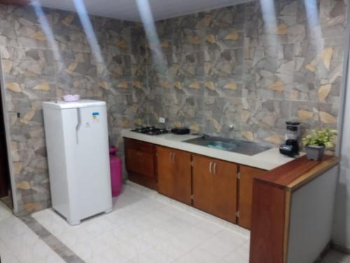 a kitchen with a sink and a refrigerator at Aparta hotel yolivacanza I in Leticia