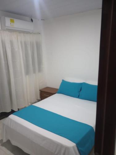 a bedroom with two beds with blue and white at Aparta hotel yolivacanza I in Leticia