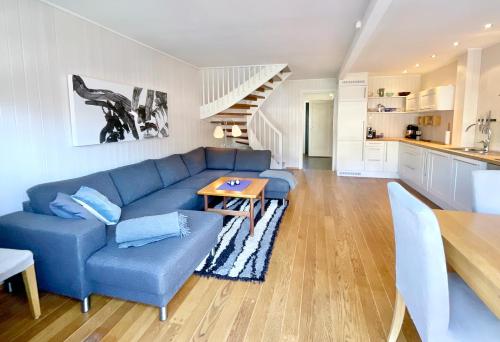 a living room with a blue couch and a table at Skottinden Panorama Lofoten in Ballstad
