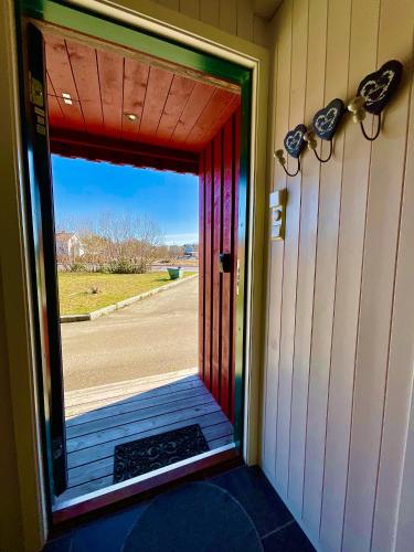 a door to a porch with a view of a street at Skottinden Panorama Lofoten in Ballstad