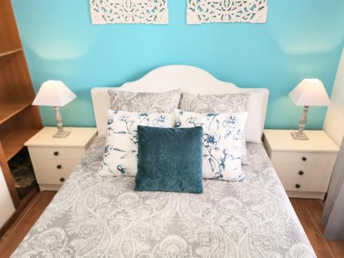 ナザレにあるApartamento Solymarの青いベッドルーム(緑の枕とベッド付)