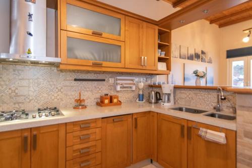 a kitchen with wooden cabinets and a sink at Family holiday home 'Arokaria' in Skaládhos