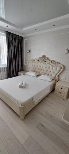 um quarto com uma grande cama branca num quarto em Отличная квартира в центре Алматы, жилой комплекс Ush Qonyr em Almaty