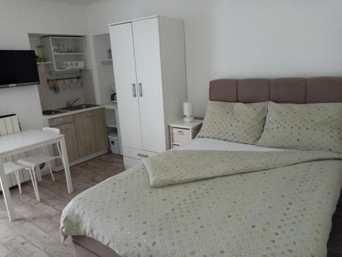 a bedroom with a large bed and a kitchen at Studio Laura in Ičići