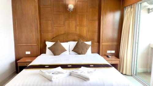 a bedroom with a bed with two white towels on it at Chalita House in Patong Beach