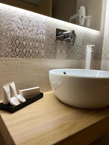 a white sink on a wooden counter in a bathroom at Maison Opéra in Bari