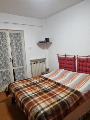 una camera da letto con un letto con una coperta scozzese sopra di A casa di Alessia a Marina di Cerveteri