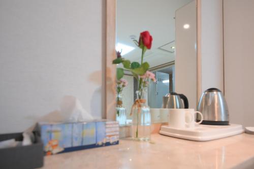 a counter with a vase of flowers and a mirror at Daeyoung Hotel Myeongdong in Seoul