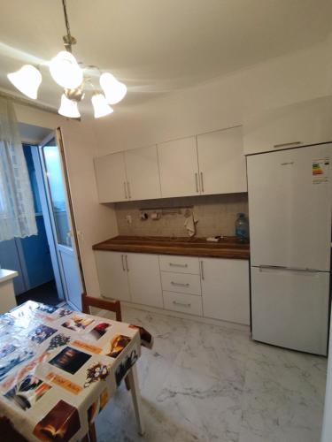 een keuken met een tafel en een koelkast bij Xata 1+2 in Alma-Ata